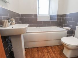 A bathroom with a bath tub and sink at Hen Blas in Pwllheli