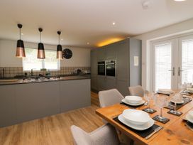A kitchen with appliances and dining area at 10 Rayrigg Rise Bowness-On-Windermere