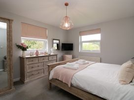 A bedroom with a bed and dresser at 10 Rayrigg Rise Bowness-On-Windermere