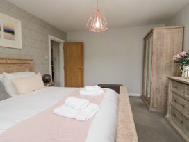 A bedroom with a bed and wardrobe at 10 Rayrigg Rise in Bowness-On-Windermere