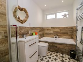 A bathroom with a sink and bathtub at 10 Rayrigg Rise Bowness-On-Windermere