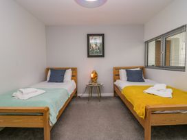 A bedroom with two beds and a nightstand at 10 Rayrigg Rise Bowness-On-Windermere