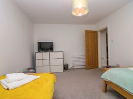 A bedroom with two beds and a television at 10 Rayrigg Rise Bowness-On-Windermere