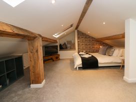 A loft bedroom with bed and television at 10 Rayrigg Rise Bowness-On-Windermere