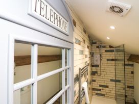 A bathroom with a shower and a telephone booth at 10 Rayrigg Rise Bowness-On-Windermere