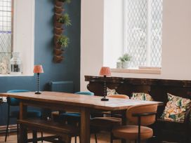 A dining room with a wooden table and chairs at Chapel of Arts in Criccieth