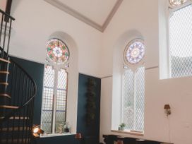 A room with a spiral staircase and stained glass windows at Chapel of Arts in Criccieth