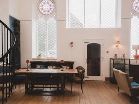 A dining room with a wooden table and chairs at Chapel of Arts Criccieth