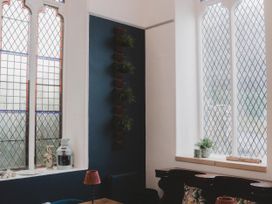 A room with stained glass windows and plants at Chapel of Arts in Criccieth