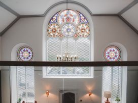 An indoor space with stained glass windows and chandelier at Chapel of Arts Criccieth