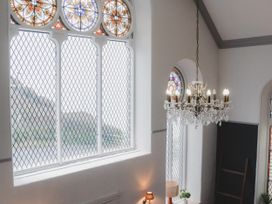 A room with a chandelier and stained glass windows at Chapel of Arts in Criccieth