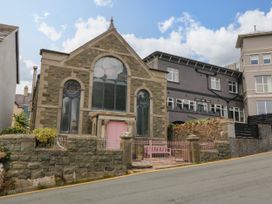 A building with large windows and a pink door at Chapel of Arts in Criccieth
