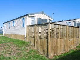 A mobile home surrounded by a wooden fence at No.73 Sennen Cove
