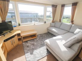 A snug with a sofa and television at No.73 Sennen Cove