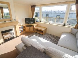 A living room with a sofa and television at No.73 Sennen Cove