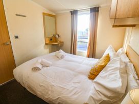 A bedroom with a bed and a mirror at No.73 Sennen Cove