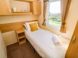 A bedroom with a single bed and a window at No.73 Sennen Cove