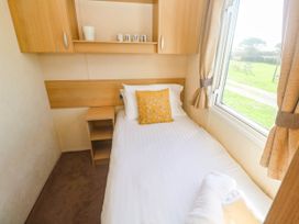 A bedroom with a single bed and shelves at No.73 Sennen Cove