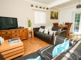 A living room with a tv and sofa at Osmington Cottage Annex