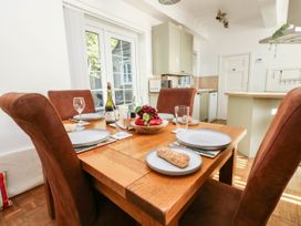 A dining table set with plates and fruit at Osmington Cottage Annex