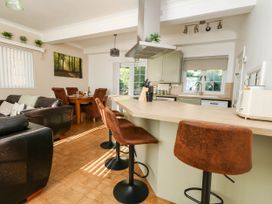 A kitchen featuring bar stools, a sink, and a dining table at Osmington Cottage Annex