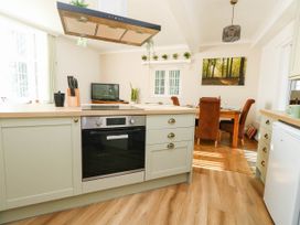 A kitchen with a stove and dining area at Osmington Cottage Annex 