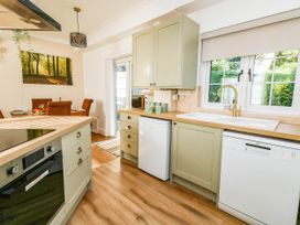 A kitchen with cabinets and appliances at Osmington Cottage Annex