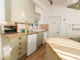A kitchen with a microwave and refrigerator at Osmington Cottage Annex