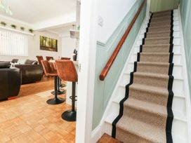 A living room with stairs and bar stools at Osmington Cottage Annex