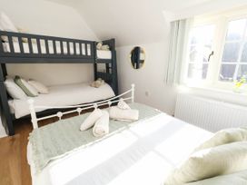 A bedroom with a bunk bed and a double bed at Osmington Cottage Annex