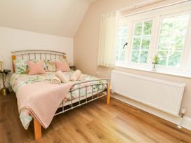 A bedroom with a bed and window at Osmington Cottage Annex