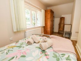 A bedroom with a bed and wardrobe at Osmington Cottage Annex 