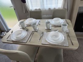 A dining table set with plates and cups at Coastfields Holiday Village Skegness