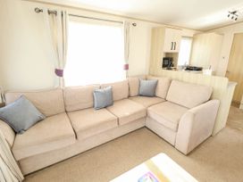 A living room with a sofa and window at Coastfields Holiday Village in Ingoldmells