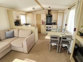 A living room with a kitchen area and dining table at Coastfields Holiday Village Ingoldmells