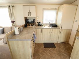 A kitchen with cabinets and appliances at Coastfields Holiday Village in Ingoldmells