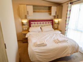 A bedroom with a bed and bedside tables at Coastfields Holiday Village Ingoldmells