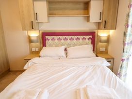 A bedroom with a bed and bedside table at Coastfields Holiday Village in Ingoldmells