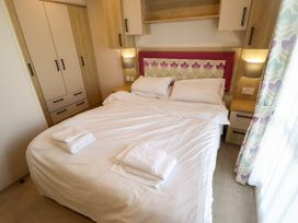 A bedroom with a double bed and wardrobe at Coastfields Holiday Village Ingoldmells