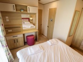 A bedroom with a bed and vanity area at Coastfields Holiday Village Ingoldmells