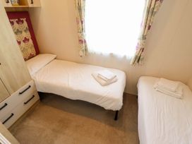 A bedroom with two single beds and cabinets at Coastfields Holiday Village Ingoldmells