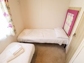 A bedroom with two beds and a window at Coastfields Holiday Village in Ingoldmells