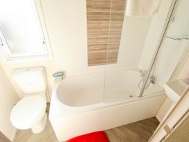 A bathroom with a shower and bathtub at Coastfields Holiday Village in Ingoldmells
