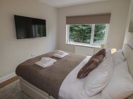 A bedroom with a bed and television at Flat 2 in Tenby