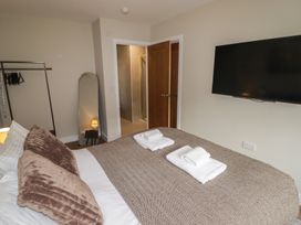A bedroom with a bed and towels on a blanket at Flat 2 in Tenby