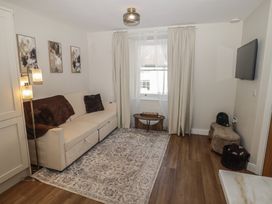 A living room with a sofa, lamp, and television at Flat 3 in Tenby