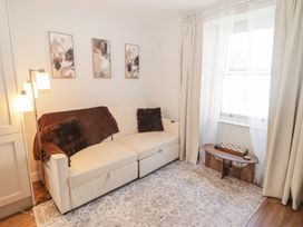 A living room with a sofa and decorative pillows at Flat 3 in Tenby