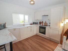 A kitchen with cabinets and appliances at Flat 3 in Tenby