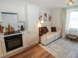 A living room with a kitchen unit and a sofa at Flat 3 in Tenby