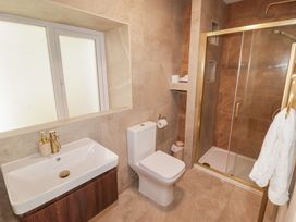 A bathroom with a sink, toilet, and shower at Flat 3 in Tenby